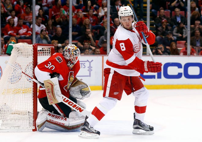 Ottawa Senators goalie Andrew Hammond (30) stops a Detroit Red Wings shot as Detroit Red Wings left wing Justin Abdelkader (8) sets a screen in the second period of an NHL hockey game Friday, Oct. 30, 2015, in Detroit. (AP Photo/Paul Sancya)