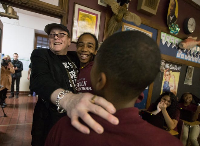 Cheap Trick's Rick Nielsen hugs seventh-grade students Andru Flores (center) and Carlos Brown on Thursday, Nov. 12, 2015, at Lincoln Middle School. Nielsen was at the school to encourage everyone to vote for his band to be inducted into the Rock and Roll Hall of Fame. SUNNY STRADER/STAFF PHOTOGRAPHER/RRSTAR.COM