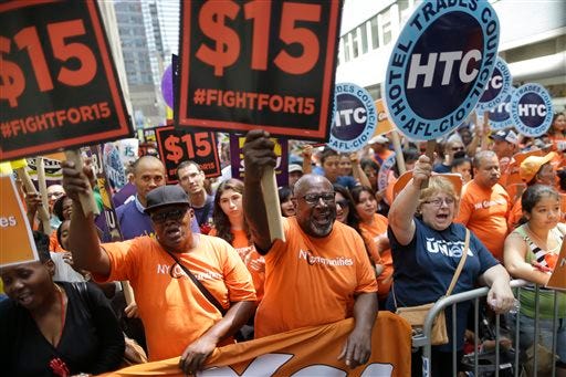 FILE- In this July 22, 2015, file photo, activists cheer during a rally after the New York Wage Board endorsed a proposal to set a $15 minimum wage for workers at fast-food restaurants with 30 or more locations in New York. The first question in the GOP presidential debate on Tuesday, Nov. 10, 2015, whether the minimum wage should go to $15 an hour, showed that U.S. workers have managed to thrust the issue of pay onto the presidential campaign agenda. (AP Photo/Mary Altaffer, File)