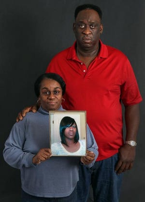 (Photo Mike Hensdill/The Gaston Gazette ) Francelia and Gregory Beam pose with a photo of their daughter Tamesha Beam who was hit and killed by a car in April.