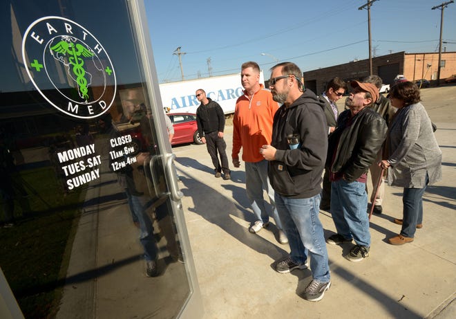 About a dozen people line up to purchase medical marijuana products at EarthMed, Monday, Nov. 9, 2015 in Addison, Ill. Regulated medical marijuana sales began Monday in Illinois with patients flocking to state-licensed retail shops in five cities around the state. (Mark Black/Daily Herald, via AP)
