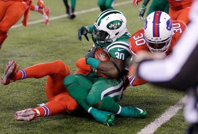 Jets kick returner Zac Stacy, center, is tackled by Buffalo Bills defensive back Jonathan Meeks, back, and strong safety Bacarri Rambo on the final play of the first half Thursday night. Stacy broke his left ankle on the play and had surgery Friday. The Associated Press