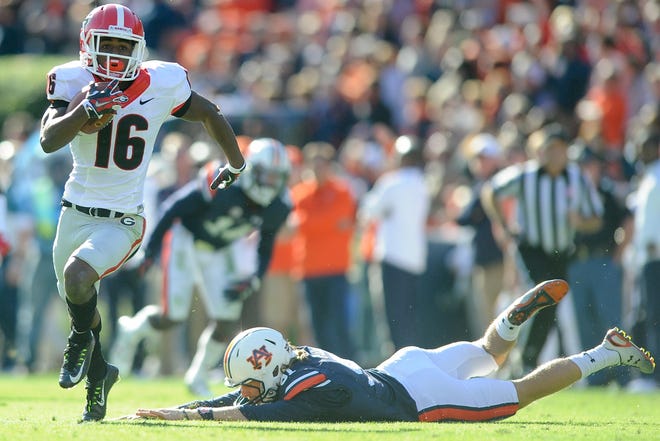 Georgia wide receiver Isaiah McKenzie (16) breaks a tackle form Auburn punter Kevin Phillips (91) while returning a punt 53 yards for a touchdown during the second half of an NCAA college football game between Georgia and Auburn on Saturday, Nov. 14, 2015, in Auburn, Ala. Georgia won 20-13. (AJ Reynolds/Staff, @ajreynoldsphoto)