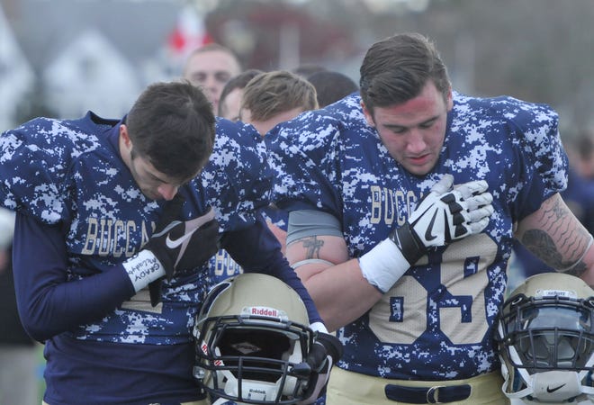 Massachusetts Maritime Academy football players pause for a moment of silence for the victims in the Paris terrorist attacks before Saturday's Cranberry Bowl game against Bridgewater State at Clean Harbors Stadium. Steve Heaslip/Cape Cod Times