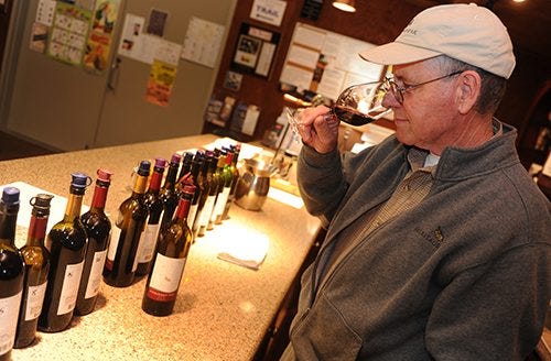 Heritage Oak Winery owner Tom Hoffman sniffs a glass of Zinfandel at his facility on East Woodbridge Road in Acampo. RECORD FILE 2015