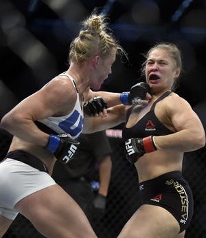 Holly Holm, left, connects with a hard left to the jaw of Ronda Rousey during their UFC 193 bantamweight title fight in Melbourne, Australia Saturday night. Holm pulled off a stunning upset victory over Rousey, knocking out the champion in the second round. The Associated Press