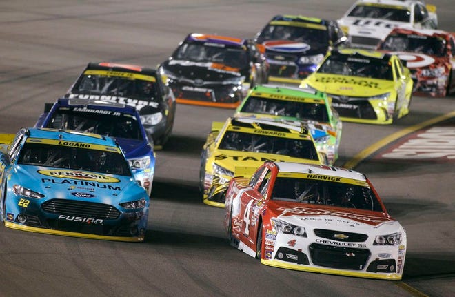Kevin Harvick (4) leads Joey Logano (22) and the rest of the field into Turn 1 during the NASCAR Sprint Cup Series auto race at Phoenix International Raceway, Sunday, Nov. 15, 2015, in Avondale, Ariz.