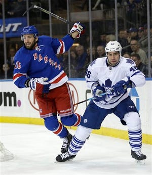 New York Rangers' J.T. Miller, left, jumps over Toronto Maple Leafs' Roman Polak's leg during the second period of the NHL hockey game, Sunday, Nov. 15, 2015, in New York. (AP Photo/Seth Wenig)