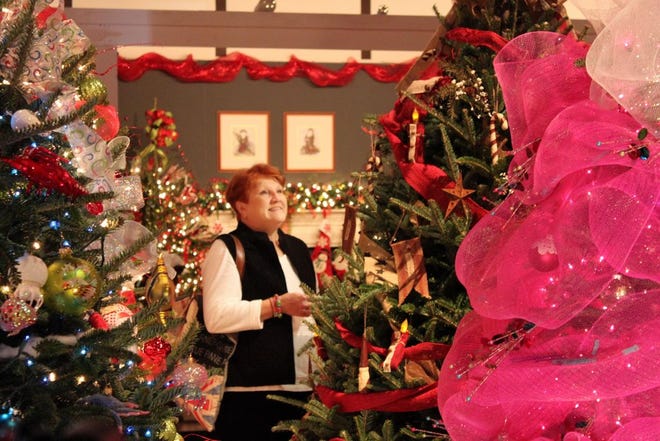 A Southern Christmas Show attendee looks at the decorated trees in Christmas Tree Lane at The Park Expo and Conference Center in Charlotte.