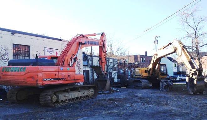 Two excavators were positioned outside a strip of long-vacant buildings on Commercial Street in Weymouth on Monday, Nov. 16, 2015, in preparation for long awaited demolition.