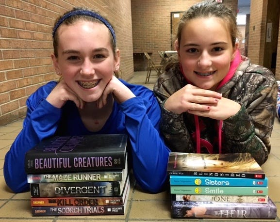 Ionia Middle School students Michaela Castle (left) and Breann Wandell pose with new books purchased through a grant awarded by Dollar General.