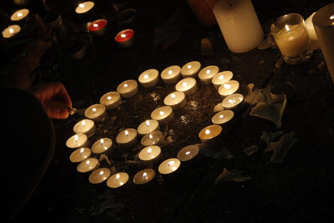 Candles are lighted outside the Bataclan concert hall in Paris on Tuesday night. AP/Christophe Ena