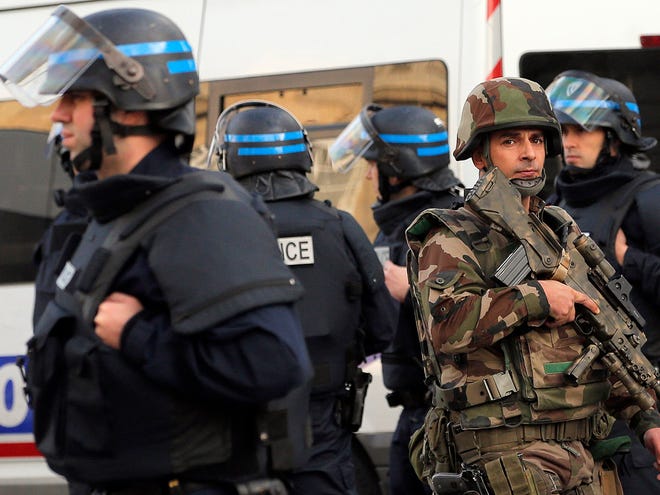 Police forces and soldiers patrol in Saint-Denis, a northern suburb of Paris, Wednesday.