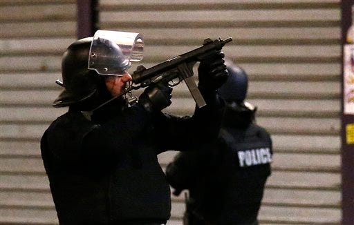 Police forces prepare for a raid Wednesday in St. Denis, a northern suburb of Paris. Authorities in the Paris suburb of St. Denis told residents to stay inside during a large police operation near France's national stadium that two officials say is linked to last week's deadly attacks.