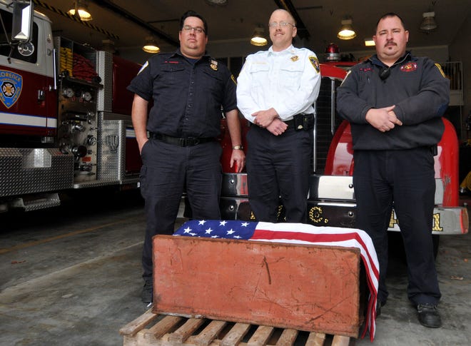 Members of the Florence Fire Department (from left) Commissioner Andrew Popso, Chief Kevin Mullen and Deputy Chief Keith Scully stand in front of a piece of steel from the World Trade Center in New York City on Wednesday, Nov. 18, 2015 inside the station.