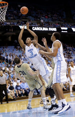 North Carolina's Kennedy Meeks puts up a shot against Wofford's C.J. Neumann, left, during Wednesday night's game. The Tar Heels' Brice Johnson, right, prepares for a rebound.
