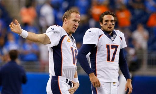 FILE - In this Sept. 27, 2015, file photo, Denver Broncos quarterbacks Peyton Manning (18) and Brock Osweiler (17) get ready for the Broncos' NFL football game against the Detroit Lions in Detroit. Osweiler gets his first NFL start in his fourth pro season, on Sunday against the Chicago Bears. Manning promises not to "be in his ear" all the time, but rest assured he will have some input. (AP Photo/Rick Osentoski, File)