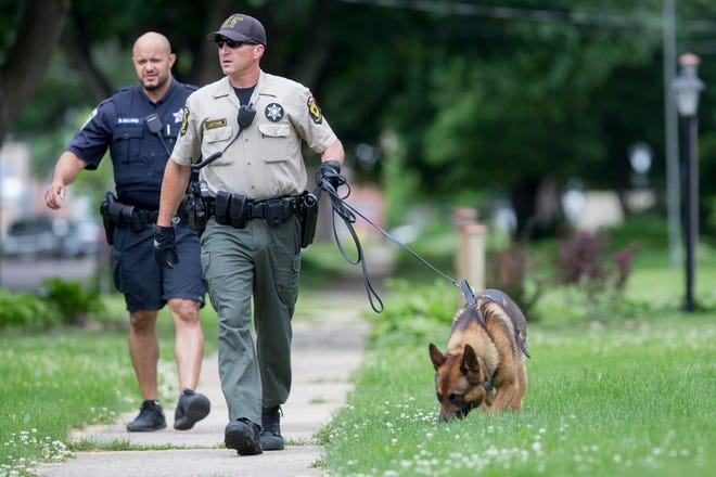 An Illinois State Trooper works with a K-9 unit Monday, June 8, 2015, on Latham Street while searching for suspects in a carjacking in Rockford. RRSTAR.COM FILE PHOTO