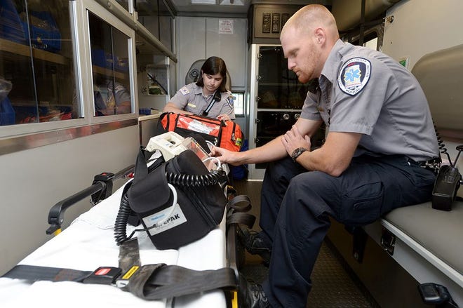 11/20/15 - Emergency medical technicians Kelli Sharpe, center, and Sparky Wrightenberry, right, check their equipment and supplies in their truck at Alamance County Emergency Medical Services Center in Graham Friday. Sam Roberts/Times-News