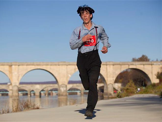 In this photo taken on Sunday, Nov. 8, 2015, Leroy Stolzfus, of Gordonville runs in the 2015 Harrisburg Marathon in Harrisburg, Pa. The Pennsylvania man turned heads as he whizzed by fellow runners at the Harrisburg Marathon, not because of his speed, but because of his unusual racing attire. Stolzfus finished the 26.2-mile race in just over three hours and five minutes - all while wearing his community's traditional clothing.