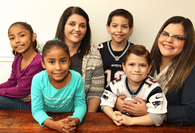 Tami, third from left, and Shelly Sepulveda, right, are neonatal intensive care unit nurses who have adopted or served as foster parents for several children born to drug-addicted mothers. Children they have adopted, from left: Shaelin, 7, Abby, 7, Sam (standing), 10, and Tyler, 6. Wednesday, Nov. 18, 2015.
