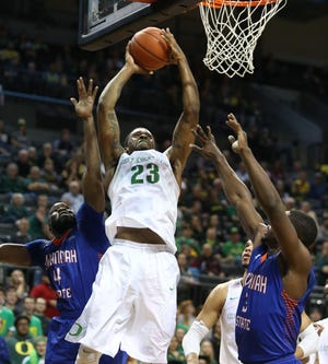 Oregon's Elgin Cook (center) goes up for a shot against Savannah State's Troyce Manassa, left, and Lenjo Kilo during the second half of an NCAA college basketball game Friday, Nov. 20, 2015, in Eugene, Ore. (Chris Pietsch/The Register-Guard)