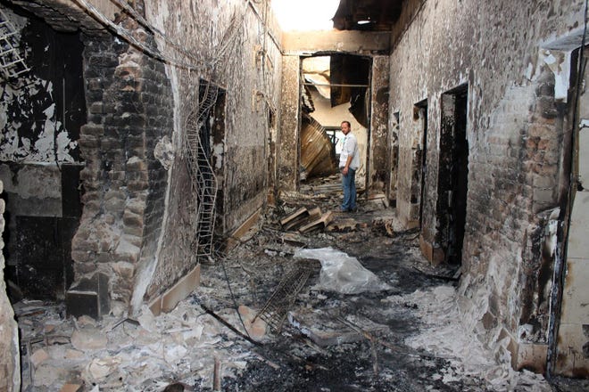 FILE - In this Oct. 16, 2015, file photo, an employee of Doctors Without Borders stands inside the charred remains of their hospital after it was hit by a U.S. airstrike in Kunduz, Afghanistan. A dozen survivors interviewed by The Associated Press are convinced that the attack on the hospital, which treated wounded Taliban and government fighters alike, was no accident. They say it was sustained and focused on destroying the main hospital building, which the aid agency says "correlates exactly" with GPS coordinates it had given to all parties in the conflict. (Najim Rahim via AP, File)