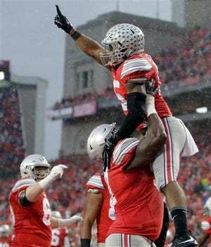 Ohio State running back Ezekiel Elliott , right, celebrates his touchdown against Michigan State with teammate Chase Farris during the second quarter of an NCAA college football game, Saturday, Nov. 21, 2015, in Columbus, Ohio.