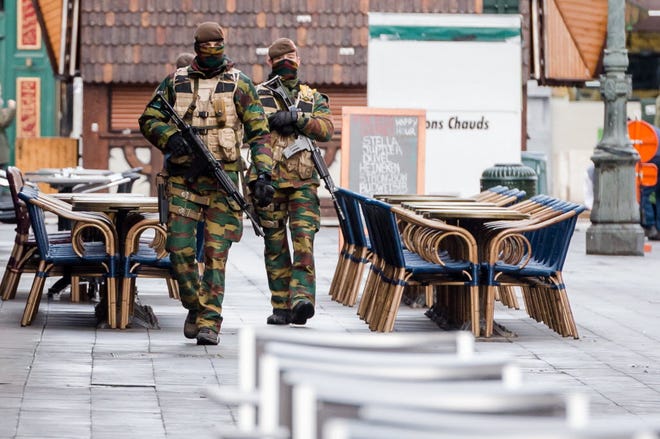 Belgian Army soldiers patrol near deserted terraces in the center of Brussels on Sunday.