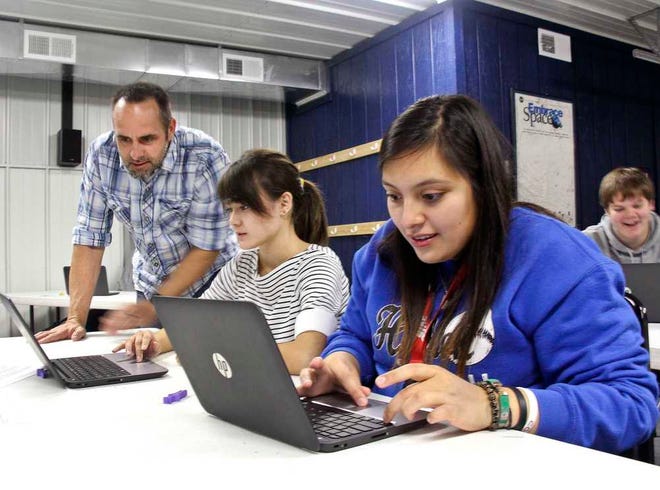 Science teacher Rich White, of Greenbush, a nonprofit education services provider, works with Holton High School physics students Abby Heitzman, left, and Alys Gomez on how to use 3D modeling software. Heitzman is aiming for a career in engineering and Gomez for a career in physics and astronomy.