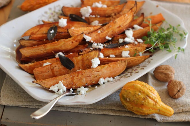 This Oct. 12, 2015, photo shows cider-glazed sweet potatoes with fried sage, garlic and goat cheese in Concord, N.H. (AP Photo/Matthew Mead)