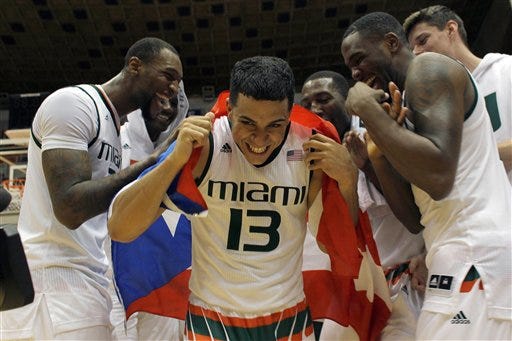 Miami"™s Angel Rodriguez, center, is congratulated by his teammates after being named MVP of the Puerto Rico Tip-Off college basketball tournament in San Juan, Sunday, Nov. 22, 2015. (AP Photo/Ricardo Arduengo)