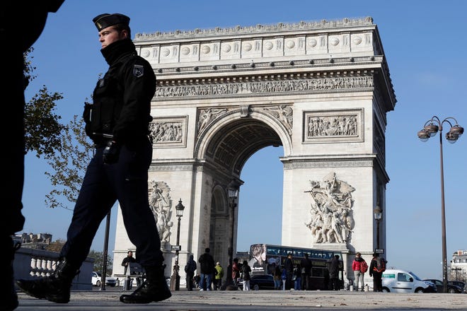 A French gendarme officer patrols in front of the Arc de Triomphe, on the Champs Elysees, in Paris, Monday. AP Photo/Laurent Cipriani