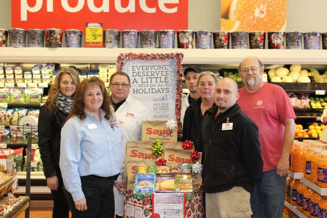 Members of the Save A Lot team in Hornell (left, front to back) Melissa Sullivan, Jessica Buck, Fran Losecco and (right, front to back), Bernie, Brenda and Colin Westbrook make a donation presentation to Gary Miles of the Salvation Army. Until Dec. 18, shoppers can purchase a prepackaged box of fixings for someone in need of a holiday dinner. JASON JORDAN PHOTO