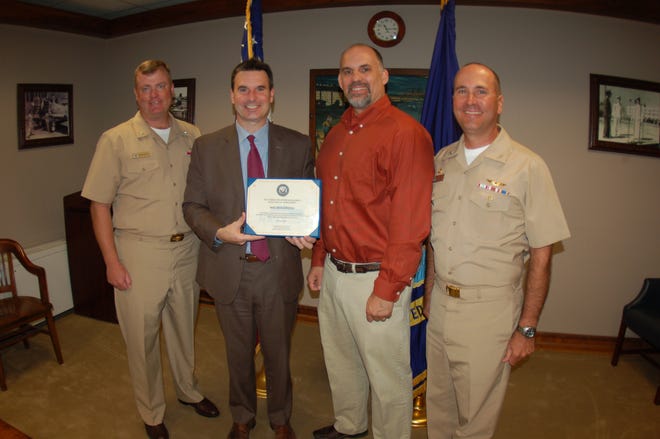Deputy Assistant Secretary of the Navy (Energy)(second from left) presents the Secretary of the Navy Energy Award Gold Level to NAS Jax Energy Manager Mike Chmura, NAS Jax Commanding Officer Capt. Howard Wanamaker (right) and Executive Officer Capt. Sean Haley on Nov. 17.