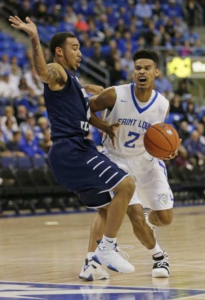 Tom Gannam Associated Press Saint Louis' Miles Reynolds drives around North Florida's Dallas Moore during the first half Tuesday night in St. Louis. UNF lost 70-57.