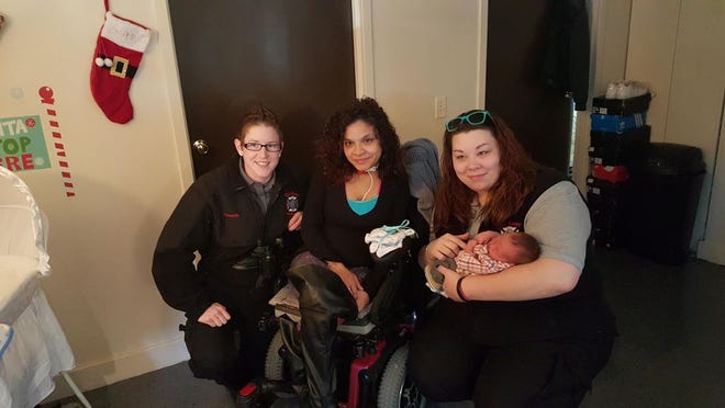 Paramedic Nicole O'Connor, Lilliana Figueroa and paramedic Meghan Fitzgerald pose as Fitzgerald holds Figueroa's baby, Jayceon. O'Connor and Fitzgerald responded to a 911 call Figueroa made, and they helped Figueroa deliver her baby at her home.