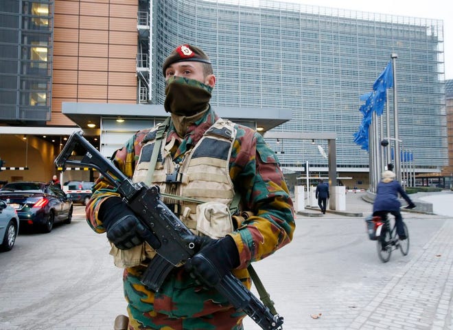 A Belgian police officer guards the building of the European Commission in Brussels, Belgium, Tuesday, Nov. 24, 2015. Brussels is keeping its terror alert at the highest level. (AP Photo/Michael Probst)