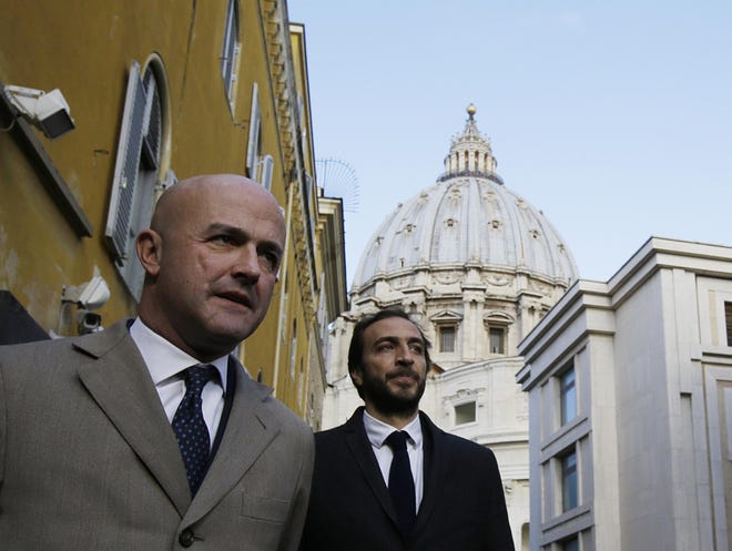 Italian journalists Gianluigi Nuzzi, left, and Emiliano Fittipaldi, leave the Vatican City from the Perugino gate, Tuesday, Nov. 24, 2015. The two Italian journalists who wrote books detailing Vatican mismanagement faced trial on Tuesday in a Vatican courtroom along with three people accused of leaking them the information in a case that has drawn scorn from media watchdogs. (AP Photo/Gregorio Borgia)