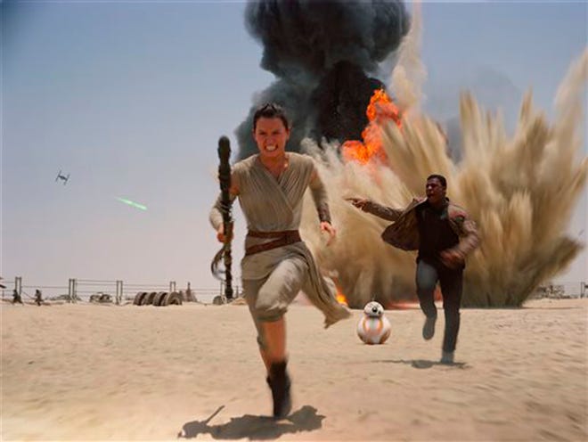 This photo provided by Disney shows Daisey Ridley as Rey, left, and John Boyega as Finn, in a scene from the new film, "Star Wars: Episode VII - The Force Awakens," directed by J.J. Abrams. The movie, which received a PG-13 rating, releases in the U.S. on Dec. 18, 2015.