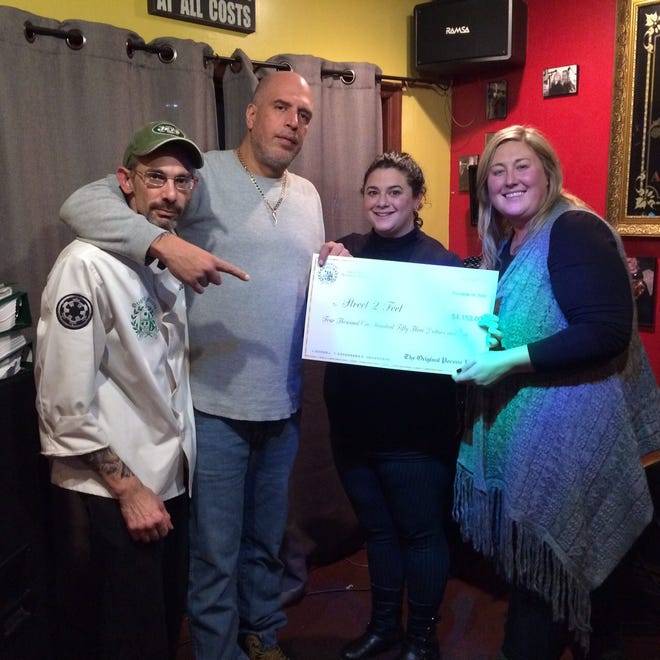 From left, James DeSantis and Stephen Bongiovanni of Pocono Pub in Stroudsburg present a $4,153 check Nov. 19 to Jacquelyn Staples of Crossroads Community Services in East Stroudsburg and Elizabeth Bogart of Street2Feet Homeless Outreach Center in Stroudsburg. The money was raised at Pocono Pub's recent benefit to assist Street2Feet, which CCS oversees, in helping the homeless. (Photo provided).