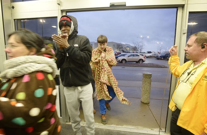 About 200 shoppers stood out in the cold last Thanksgiving to be the first to take advantage of deals at Best Buy in Center Township. Some had been in line as early as 9 a.m. Here, Best Buy employee Benjie Tiberis opens the doors for shoppers at 5 p.m.