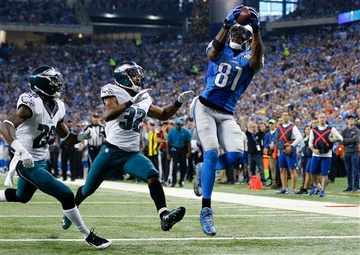 Detroit Lions wide receiver Calvin Johnson (81) catches a 25-yard pass for a touchdown defended by Philadelphia Eagles strong safety Walter Thurmond (26) and cornerback Eric Rowe (32) during the first half of an NFL football game, Thursday, Nov. 26, 2015, in Detroit. (AP Photo/Rick Osentoski)