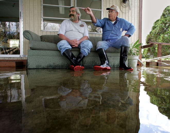Roger Martinez, left, and Ed Perkins sit ankle deep in water at Spring Lake Park in Lake Wales after Hurricane Wilma in 2005. Wilma was the last hurricane to make landfall in Florida.