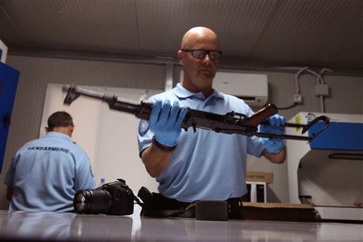 A United Nations investigator inspects a weapon that was allegedly used by gunmen during the recent attacks on the Radisson Blu hotel, in Bamako, Mali, Tuesday, Nov. 24, 2015. Islamic extremists armed with guns and grenades stormed the luxury Radisson Blu hotel in Mali's capital on Friday, Nov. 20, 2015. (AP Photo/Baba Ahmed)