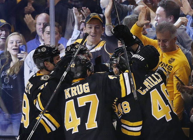 Boston's Torey Krug (47) Colin Miller (48) and teammates celebrate a go-ahead goal by David Krejci, back right, late in the third period against the Rangers on Friday afternoon.