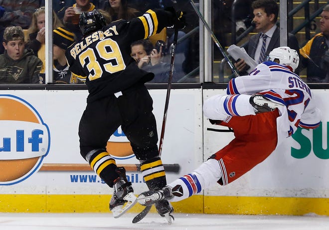 Bruins' Matt Beleskey (39) slams Rangers center Derek Stepan into the boards during the second period of Friday's game in Boston. Stepan broke several ribs on the play. The Associated Press
