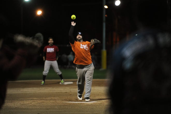 Ryan Burgoyne pitches for the "Nation of Domination" team during a softball game at Trum Field as part of the Boston Ski and Sport's Club's Fall Frostbite League on Friday, Nov. 20. For more photos, see page B1.

Wicked Local staff photo / Kate Flock