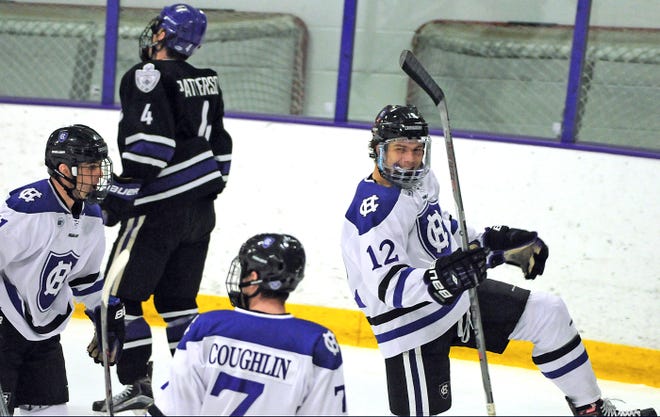 Holy Cross' Scott Pooley, right, celebrates his first period goal versus Niagara with teammates Michael Laffin, left, and Johnny Coughlin on Saturday. T&G Staff/Steve Lanava