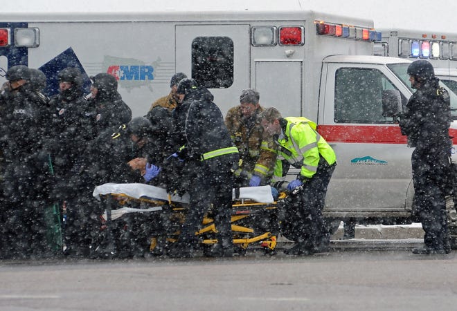 A police officer is transported to an ambulance near a Planned Parenthood clinic Friday, Nov. 27, 2015, in Colorado Springs, Colo.